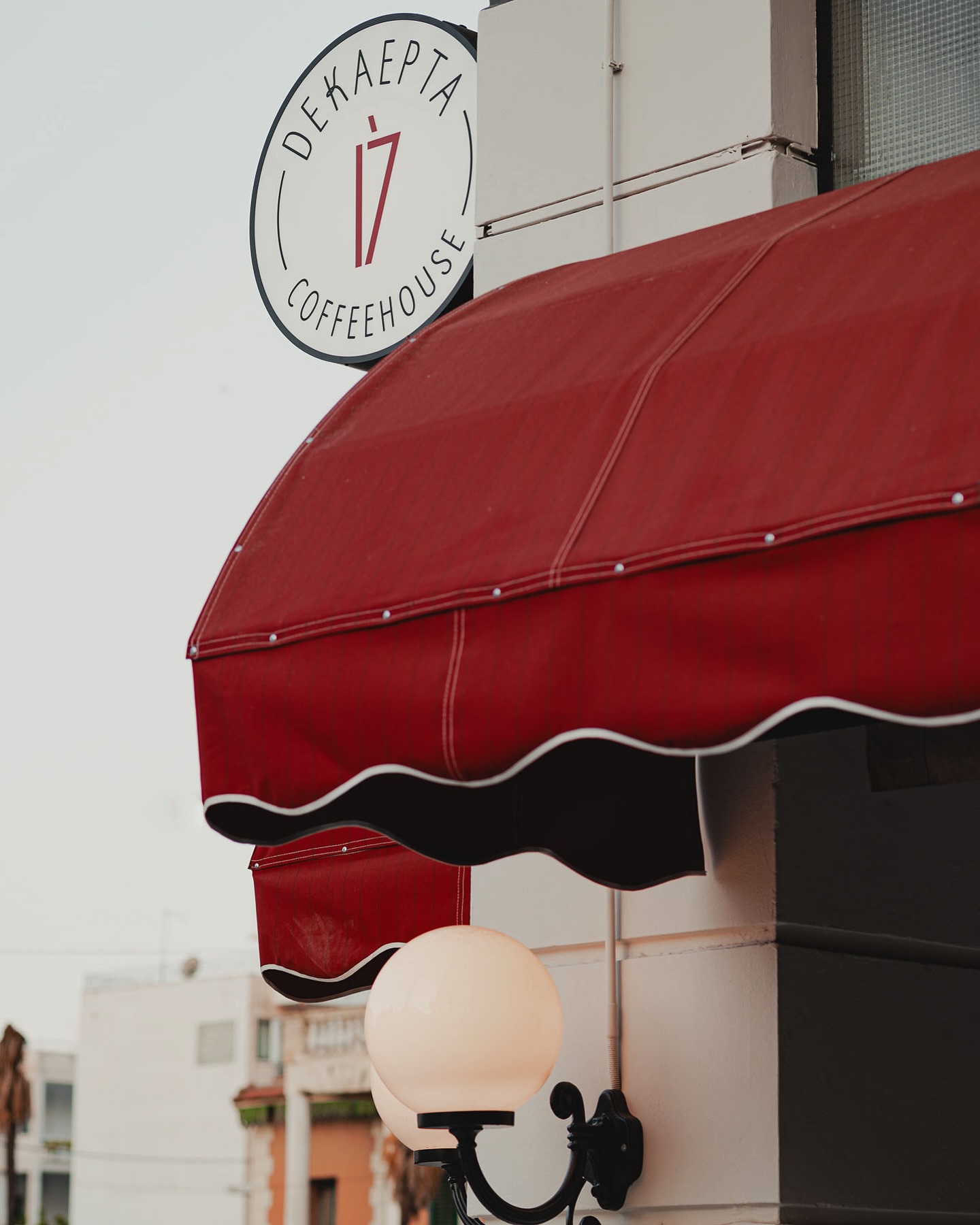 Η μπορντό τέντα και το σήμα του Dekaepta Coffeehouse
